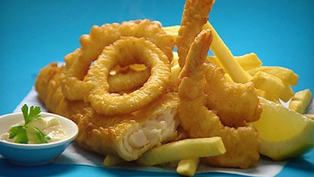 Golden fried fish and chips, with a side of lemon and tartar sauce